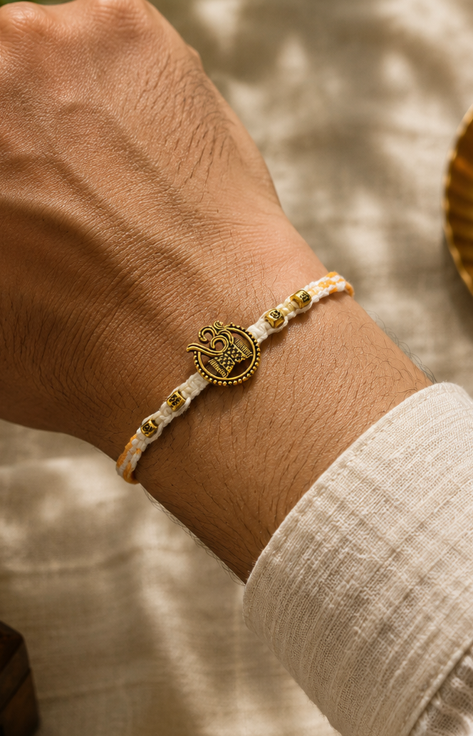 Om Damru in yellow and white thread rakhi with rice, haldi & kum kum dibbi gift pack