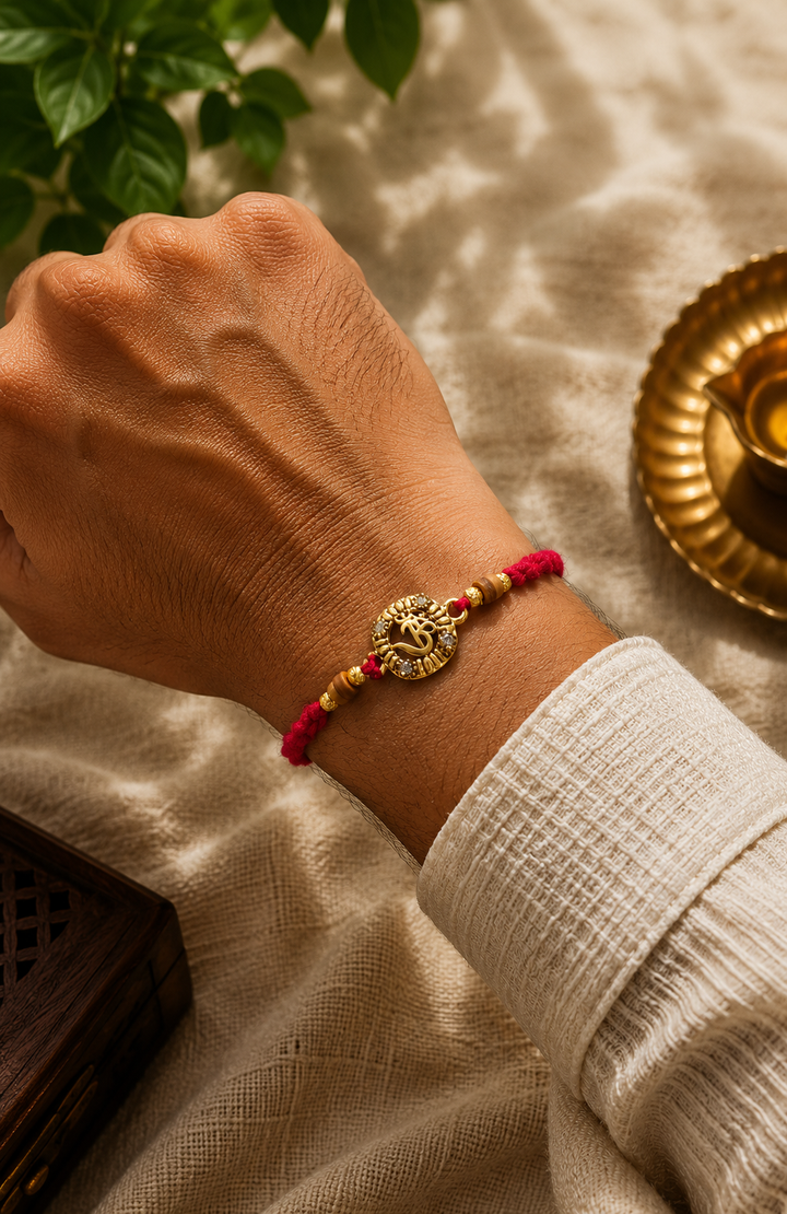 Radiating Om rakhi with rice, haldi & kum kum dibbi gift pack.